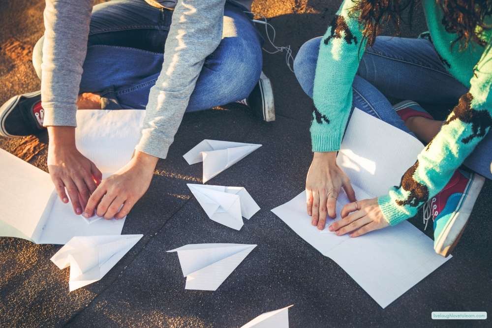 Students folding and testing paper airplanes during a hands-on STEM challenge activity at the end of the school year.