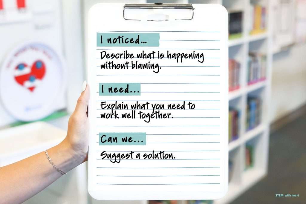 Teacher holding a clipboard showing the “I noticed, I need, Can we” conflict resolution script to help students solve disagreements during STEM group work.
